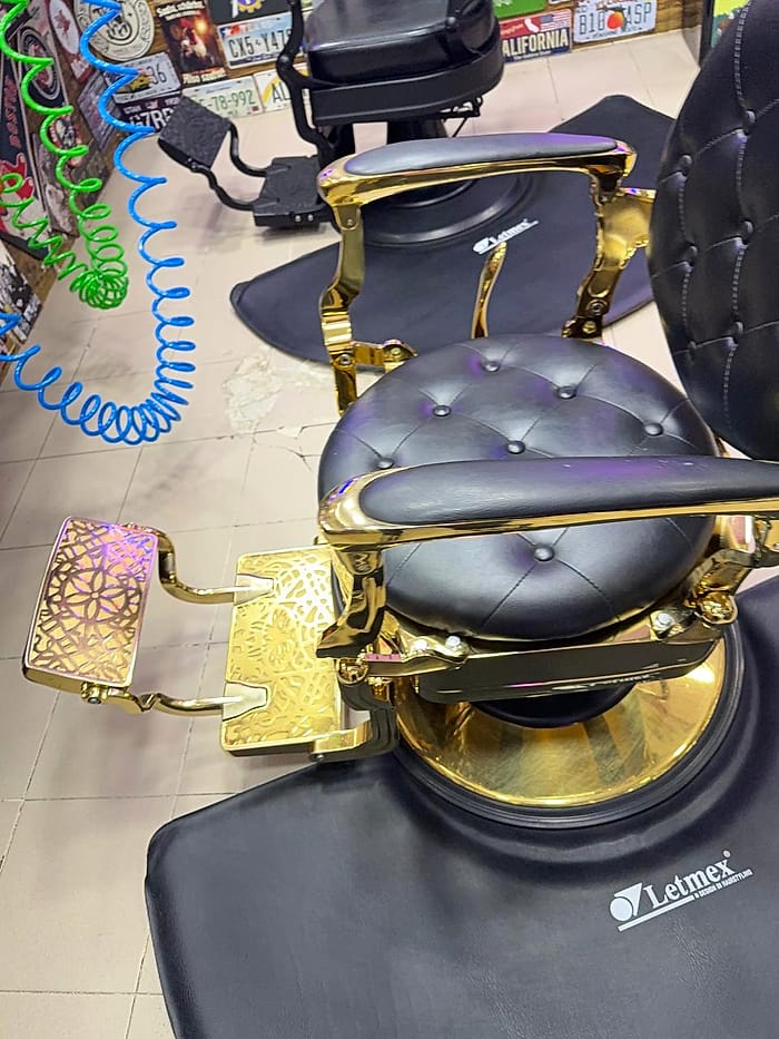 Silla de barbero negra con detalles dorados